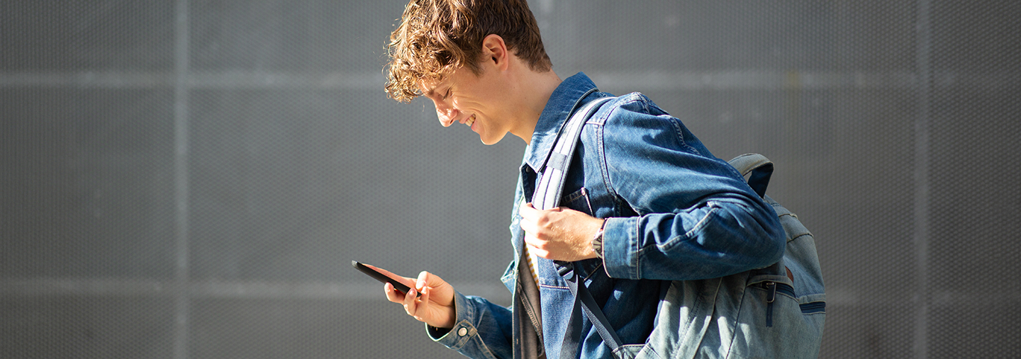 Lächelnder Junge schaut aufs Handy